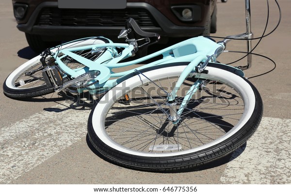 Car and\
bicycle accident on road of city\
street