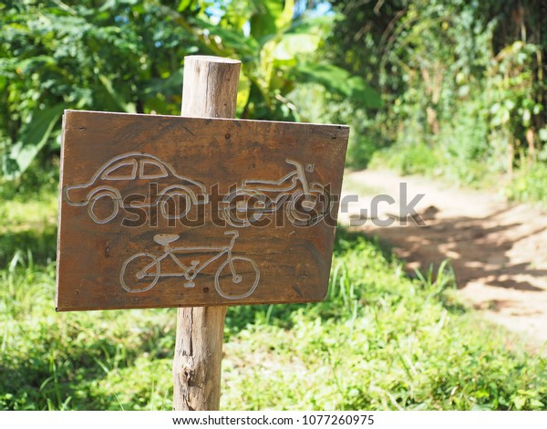 Car Bicycle Motorcycle symbol in
square wooden sign with natural tree and grass background 
