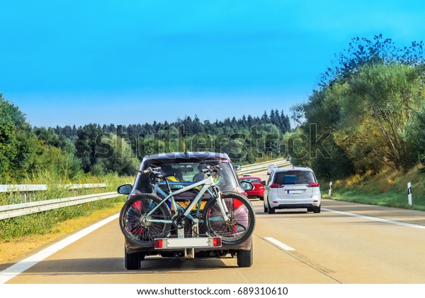 Car with\
bicycles in the highway in\
Switzerland.
