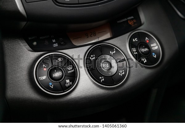 Сlose-up of the car  black interior:  dashboard,\
adjustment of the blower, air conditioner, accelerator handle and\
other buttons. 