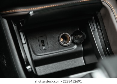 Сlose-up of the car  black interior:  power outlet 12V, USB, AUX and other buttons. 