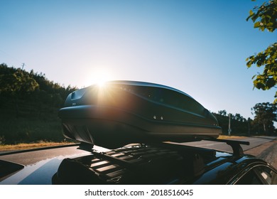 Car With Black Plastic Rooftop Cargo Box Or Roof Carrier For Traveling. Removable Storage Container Mounted On Car Roof Rack