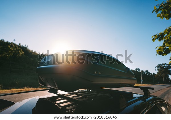 Car
with black plastic rooftop cargo box or roof carrier for traveling.
Removable storage container mounted on car roof
rack