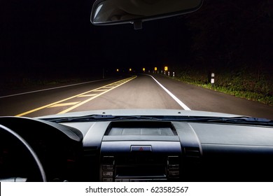 In the car, blur of dark road in the forest as background.