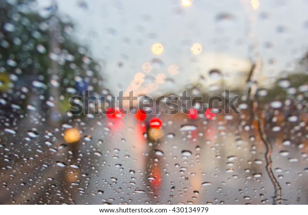 In the car, blur image of heavy rain on the\
road at night as background.