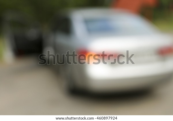 The car is a blur. Silver car parked with the hazard\
lights .