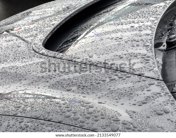 Car body\
part covered with multiple water rain\
drops