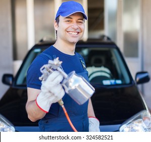 Car Body Repairer Holding A Spray Gun