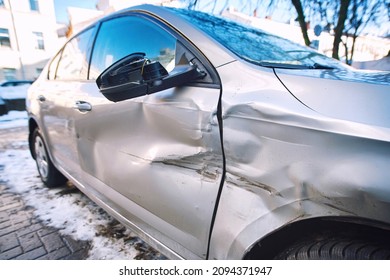 Car body side damage, traffic accident in winter season. Car door damage, broken and damaged side mirror on car door.