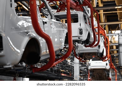 Car body transported by hanging conveyor in plant workshop - Shutterstock ID 2282096535