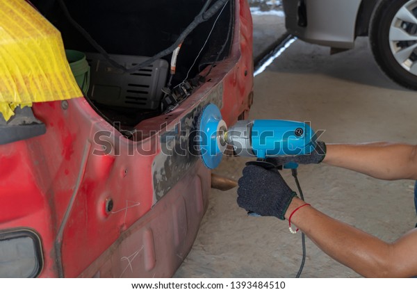 Car body work ,Repair\
service worker fix damaged car. Working with angle grinder to fix\
metal body. 