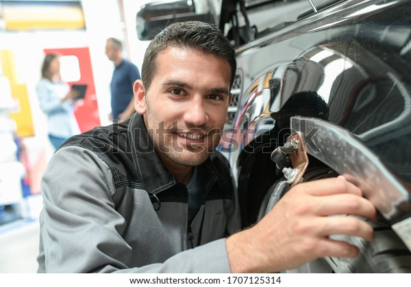 Car body worker\
repairs domage on a car