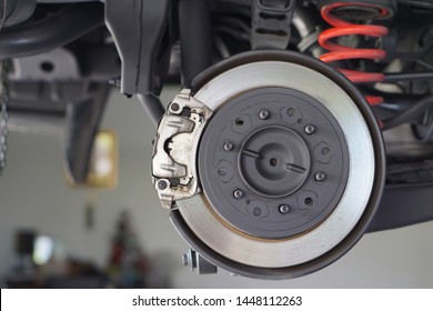 Car brake part at garage,car brake disc without wheels.Suspension of car in car service. Close up.         - Shutterstock ID 1448112263