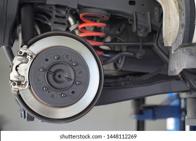 Car brake part at garage,car brake disc without wheels.Suspension of car in car service. Close up.         - Shutterstock ID 1448112269