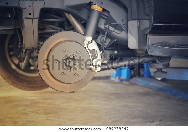 Car brake part at garage,car brake disc without\
wheels closeup.Close up.