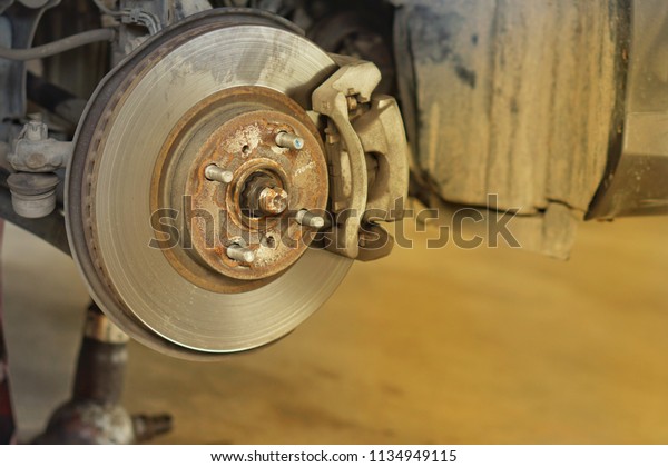 Car brake part at garage,car brake disc without\
wheels closeup.Close up.
