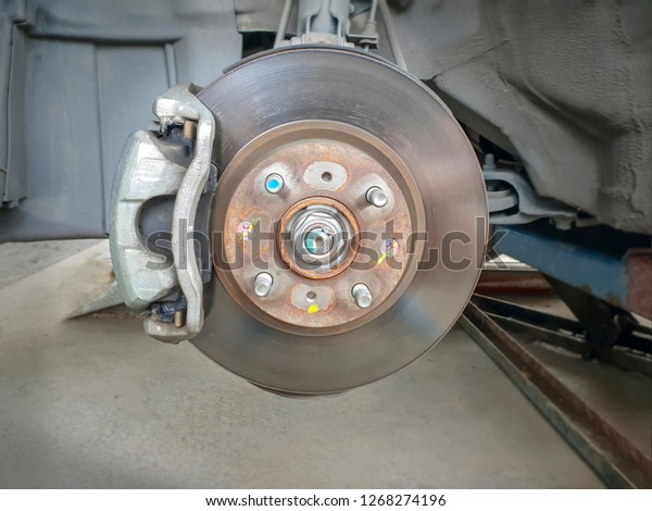 Car brake part at garage,car brake disc without\
wheels closeup