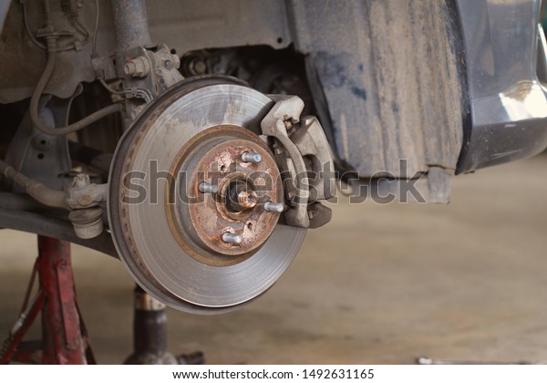 Car\
brake part at garage,car brake disc without wheels.Suspension of\
car in car service. Close up.                       \
