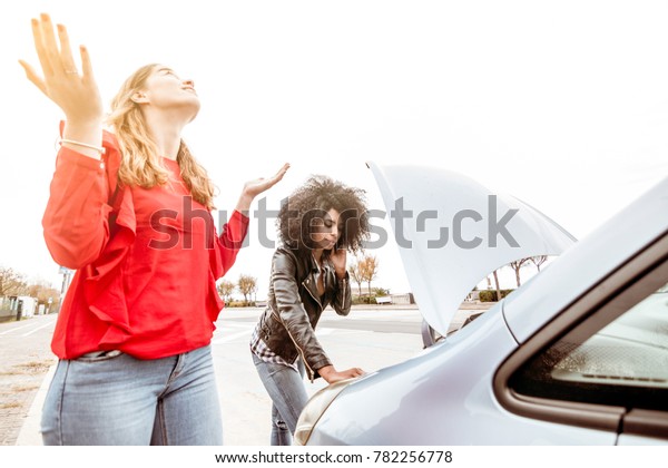 car break down with
engine trouble. woman is angry and her girl friend calls for
emergency assistance.