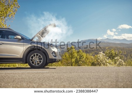 Car breakdown, SUV with an open hood and smoke on the road