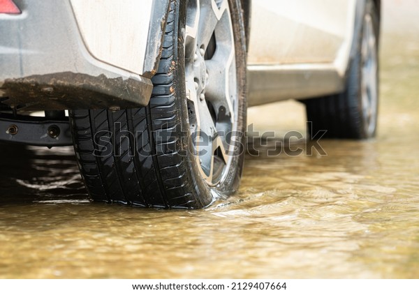 A\
car is breakdown in water flood road, transportation scene photo.\
Close-up and selective focus at the wheel\'s tire\
part.