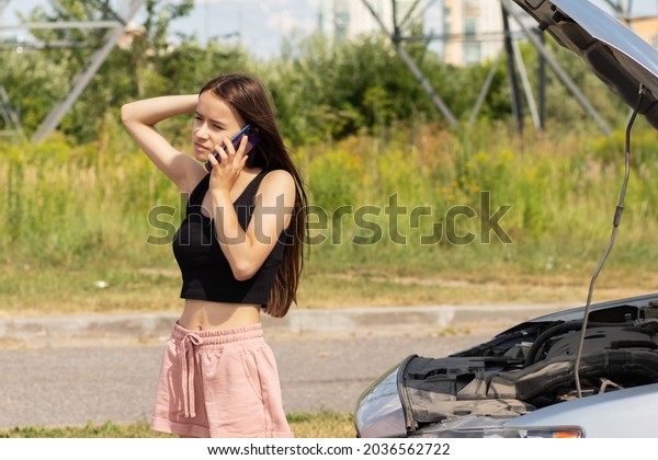 car\
breakdown,woman driver  on the road is sad with an open hood,help\
is called by phone,problems on the\
way