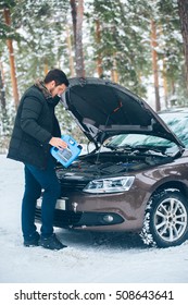 The Car Broke Down. Beautiful Young Driver Trying To Fix The Car In The Woods In Winter. Ended Oil.