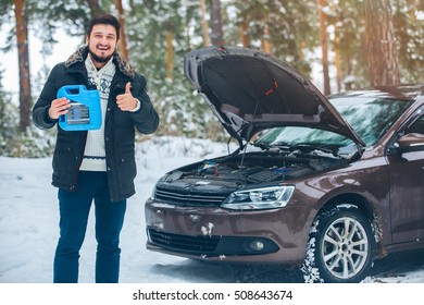 The Car Broke Down. Beautiful Young Driver Trying To Fix The Car In The Woods In Winter. Ended Oil.