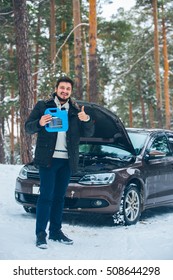 The Car Broke Down. Beautiful Young Driver Trying To Fix The Car In The Woods In Winter. Ended Oil.