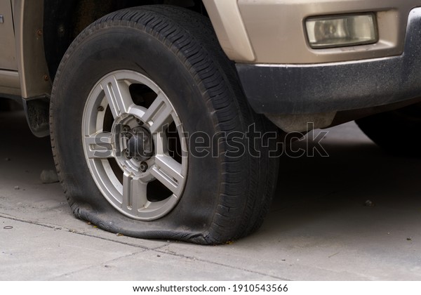 A car\
with a broken front wheel parked on the\
road.