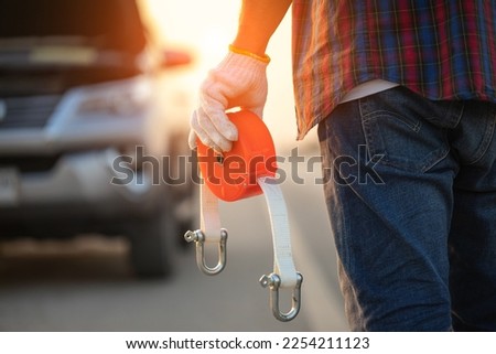 Car broken on the road. Man holding emergency car towing line and standing infront of car on the roadside. Car accident, repair and maintenance concept