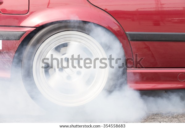 A car burnout at a\
drag racing track