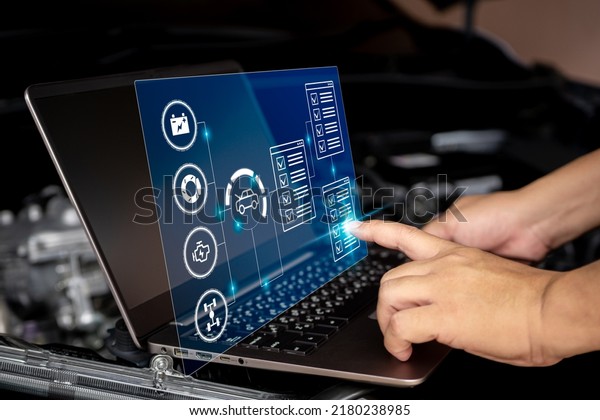 Car business and service concept, Technician use\
laptop to check car service in the digital list battery brake\
engine suspension on virtual screen,Technology of car maintenance\
in car service center