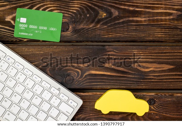 Car buying and\
insurance concept with car, credit card and keyboard on wooden\
background top view mock up