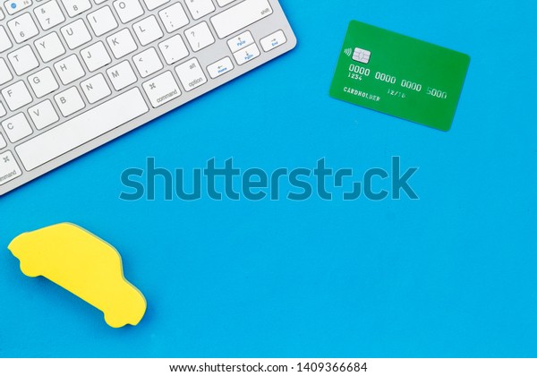 Car buying and insurance\
concept with car, credit card and keyboard on blue background top\
view mock up
