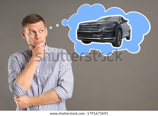 Car\
buying. Man dreaming about auto on grey\
background
