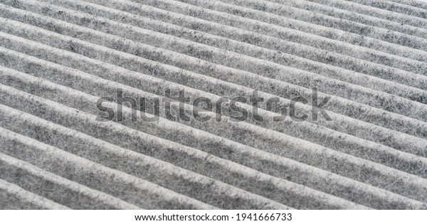 Car cabin charcoal air filter texture\
background. Carbon car air filter.  Quality spare parts for car\
service or maintenance
