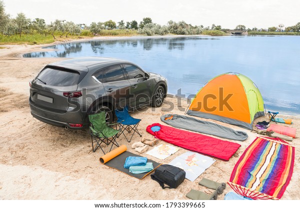 Car and
camping equipment on sandy beach. Summer
trip