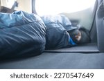 car camping, man sleeping inside of car with sleeping bag
