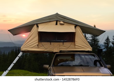 Car Camping Tent On The Rooftop Of An SUV In Mountains