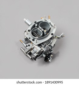 Car carburetor for internal combustion engine for mixing air with a fine spray of liquid fuel on gray background, side view. Automotive parts.