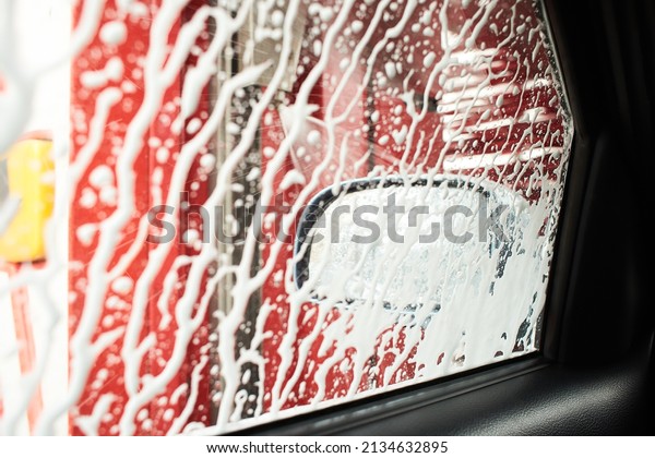 Car Care Business.\
Automatic Car Wash Process. Spray foam bubble shampoo on the car\
surface and Tire.