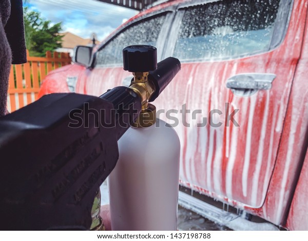 Car Care Business. Car Wash Process. Spray\
foam bubble shampoo on the car\
surface.