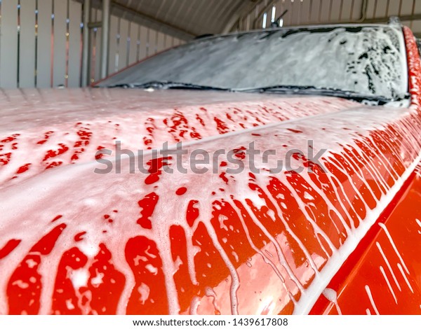 Car Care Business. Car Wash\
Process. Spray foam bubble shampoo on the car surface and\
Tire.