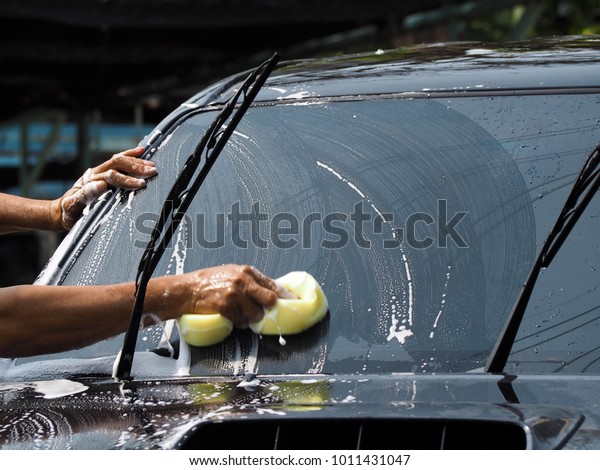 Car care clean service. A man wash vehicle use\
by sponge and car\
cleansing.
