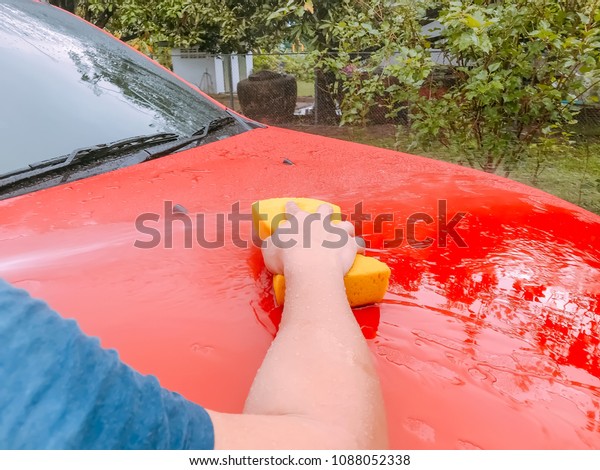 Car Care or Car Detailing business. \
Washing the car surface with yellow\
sponge.
