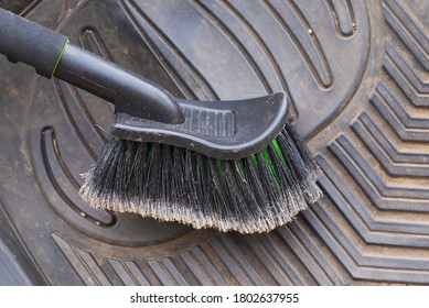 Car Care In The Fall. Step-by-step Dust Cleaning Of Dirty Rubber Car Mats With A Dry Brush. Close-up