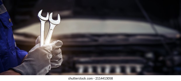 Car care maintenance and servicing, Close-up hand technician auto mechanic using the wrench to repairing change spare part car engine problem and car insurance service support. - Shutterstock ID 2114413058