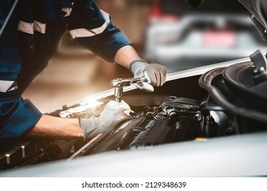 Car care maintenance and servicing, Close-up hand technician auto mechanic using the wrench to repairing change spare part car engine problem and car insurance service support. - Shutterstock ID 2129348639