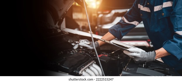 Car care maintenance and servicing, Close-up hand technician auto mechanic checking inspection list after repairing change spare part car engine problem and car insurance service. - Shutterstock ID 2222515247